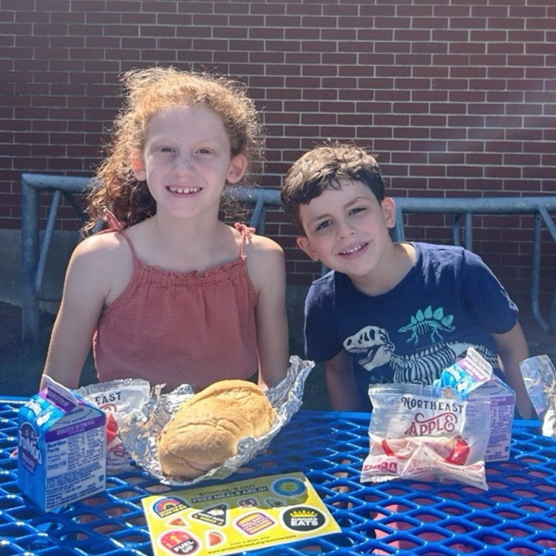Two kids emjoy Summer Eats at Phelps Elementary School.