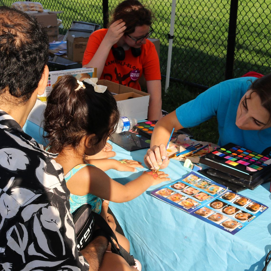A kid gets their hand painted.