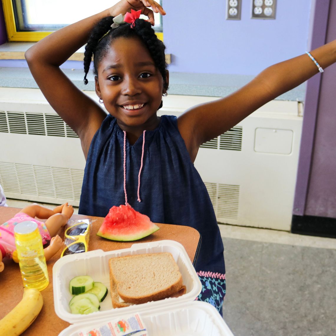 A kid enjoys Summer Eats at Orchard Gardens in Roxbury