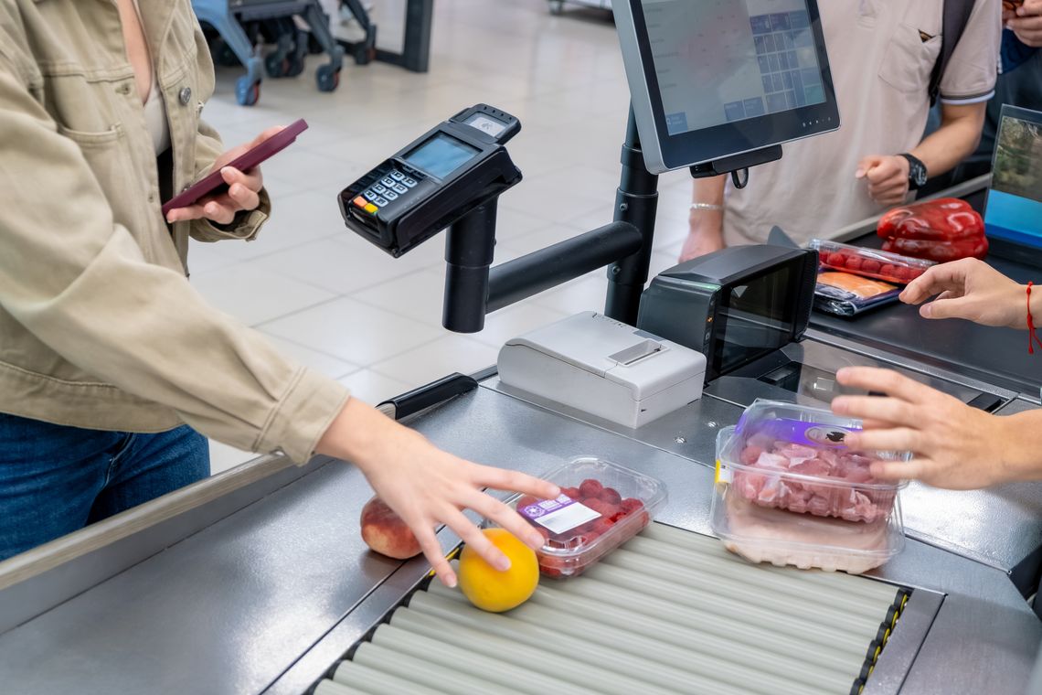 Grocery shoppers at checkout buying produce and packaged meat